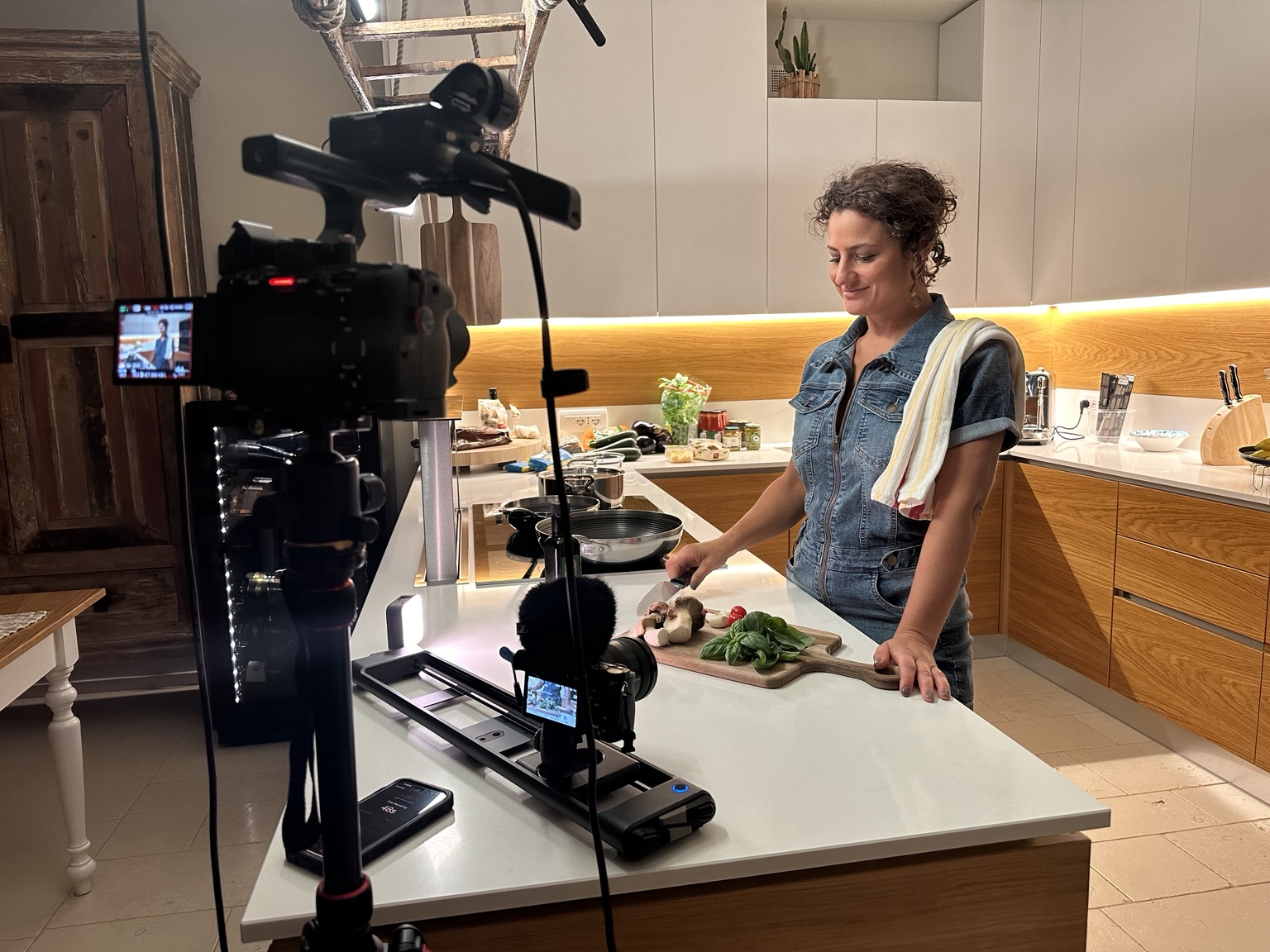 Christina cooking in a kitchen during filming