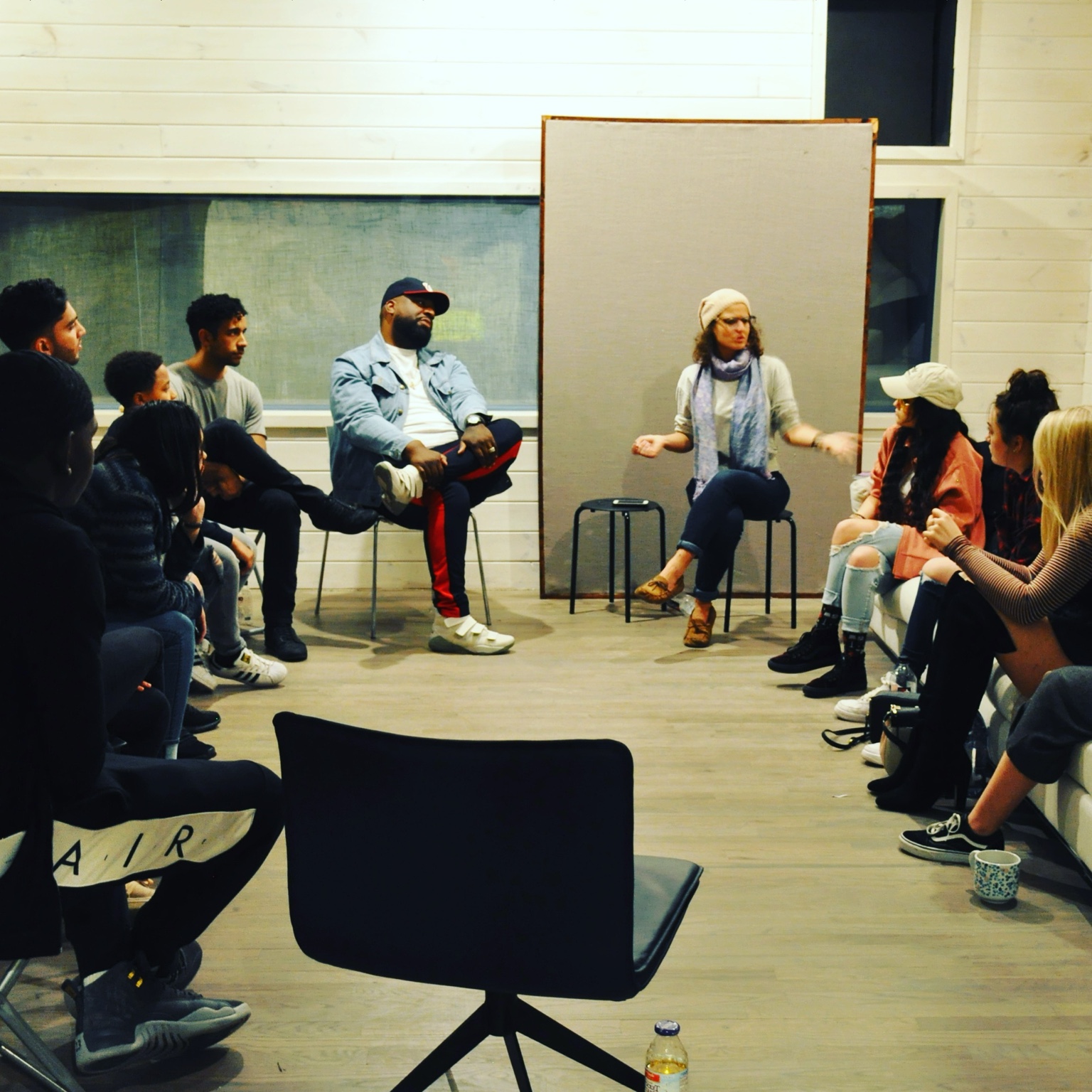 Christina speaking with a circle of artists during a group session