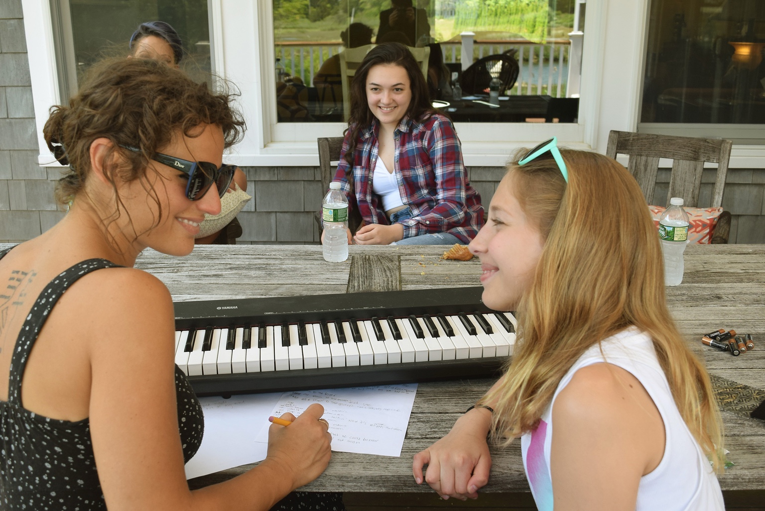 Christina sharing a songwriting moment with young artists around a keyboard
